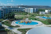 Piscina infantil con barco y edificios del hotel
