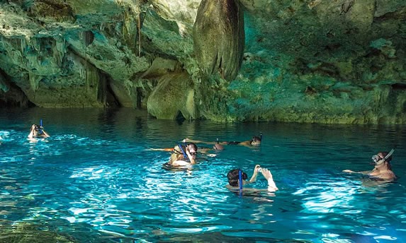 Tourists snorkeling in the cenote