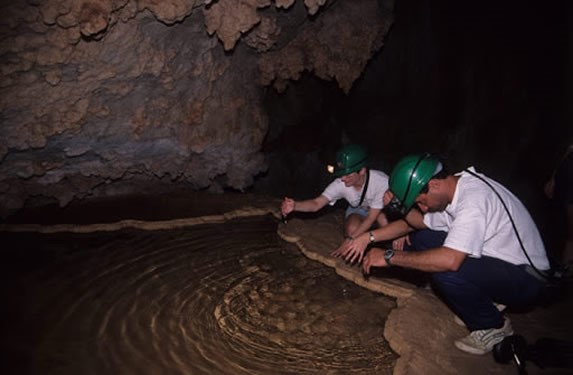 turistas observando el agua en la cueva