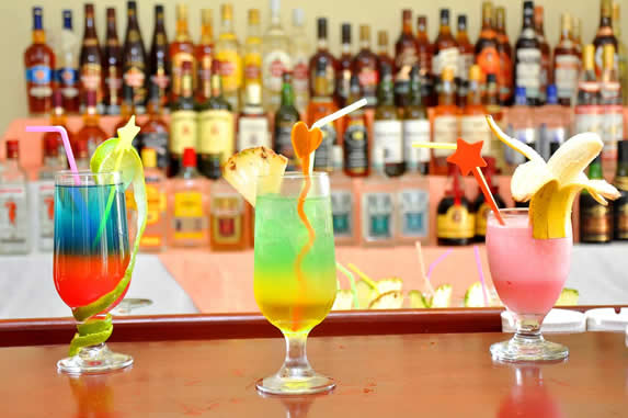 colorful drinks prepared on the wooden bar