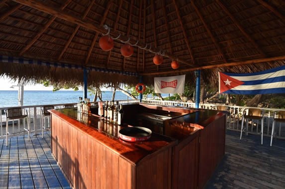 wooden bar under guano roof facing the sea