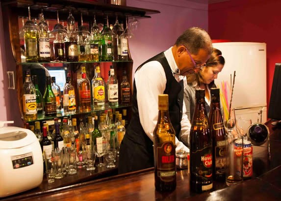 Wooden bar with bottles on shelves.