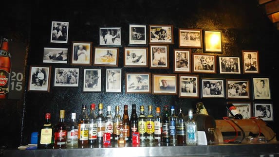 wooden bar with decorative frames and bottles