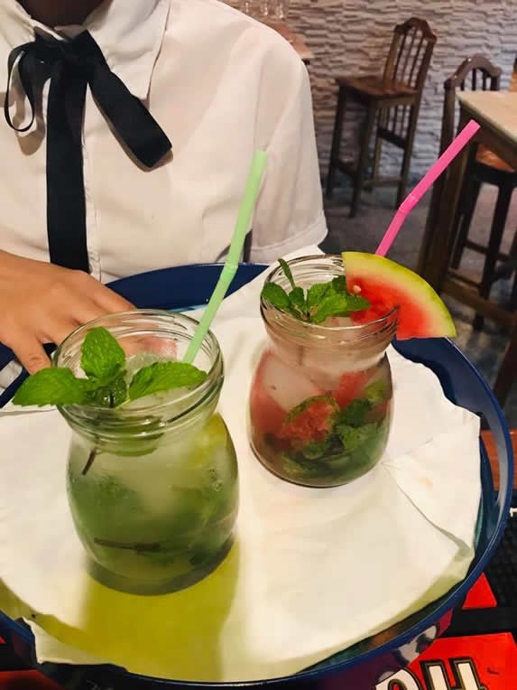 waitress showing decorated drinks