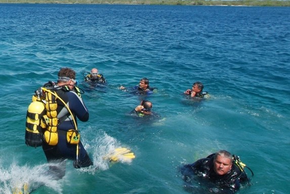 group of divers jumping into the water