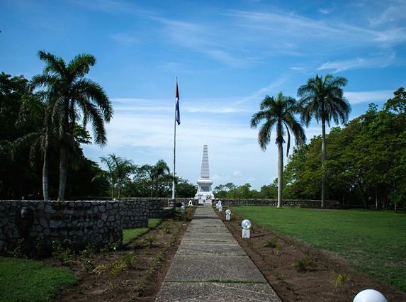 camino de cemento y monumento de mármol al fondo 