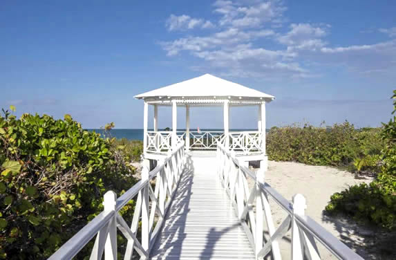 wooden path with white pergola on the beach