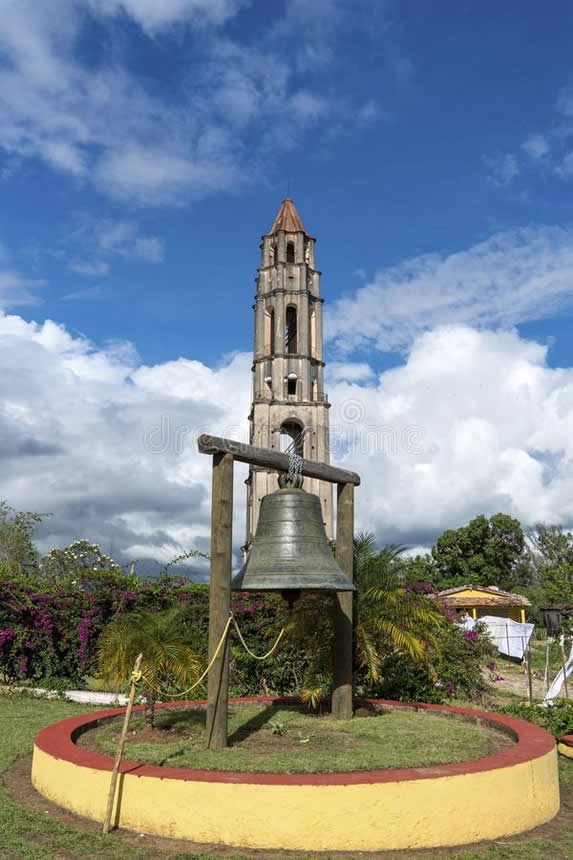 campana y torre colonial rodeada de vegetación 