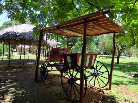 carreta bajo techo de tejas rodeada de árboles