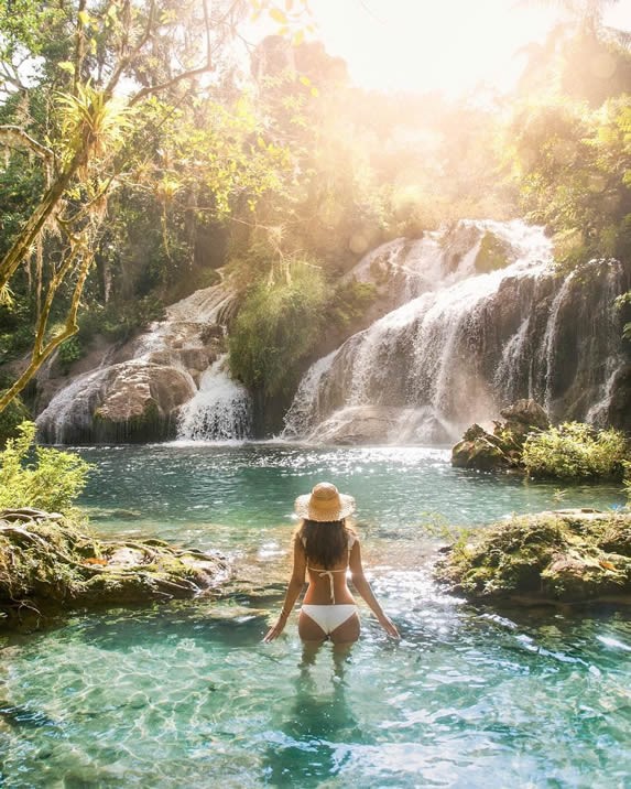 turista en la laguna con cascadas al fondo