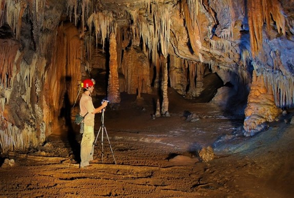 turista con casco en el interior de la cueva 