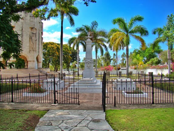 marble sculpture behind bars surrounded by palms