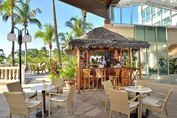 beach bar surrounded by palm trees and tables