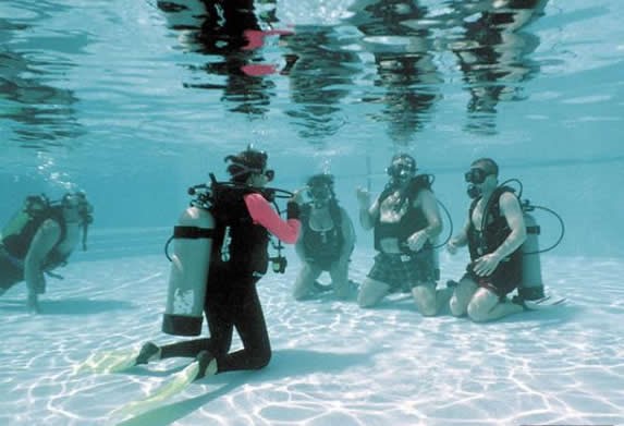 buzos aprendiendo en piscina poco profunda