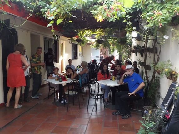 clientes sentados en patio rodeado por vegetación