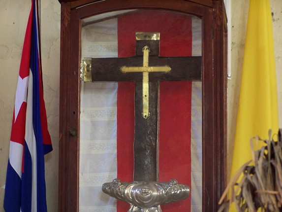 cruz de madera con detalles dorados en una vitrina