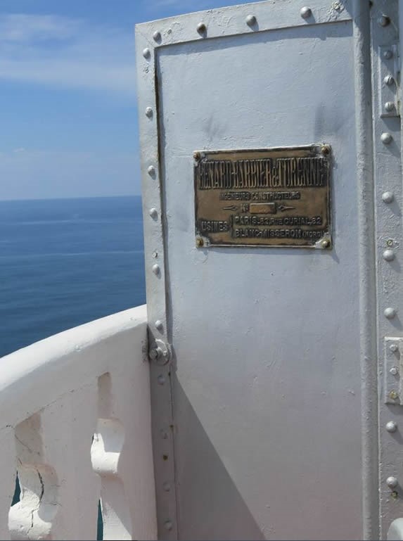 balcón con puerta de metal y vista al mar azul