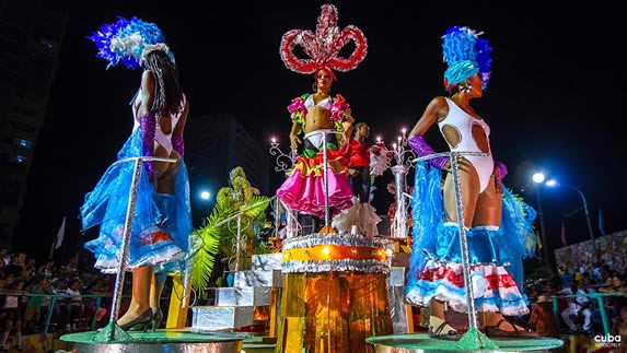 bailarines con coloridos vestuarios en una carroza