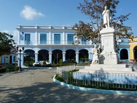 estatua en el parque y edificio colonial al fondo