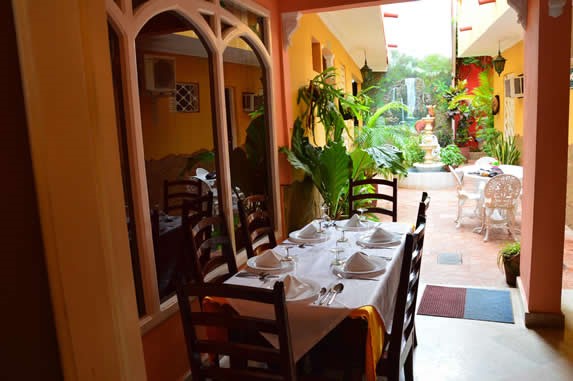 Restaurant courtyard with tables and vegetation.