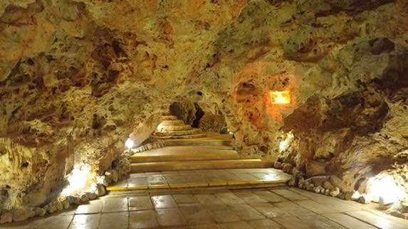 entrance to the cave with lights between the rocks