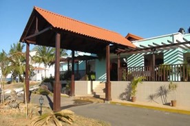 entrada del hotel con tejado y vegetación