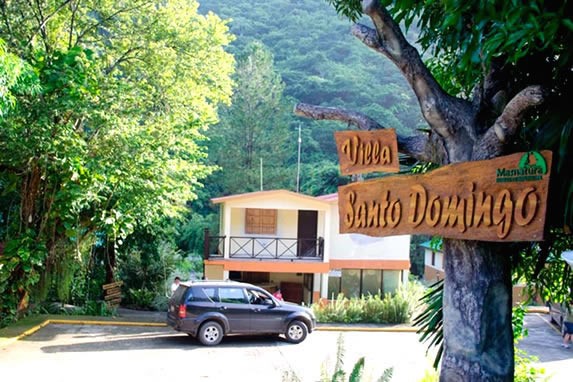 hotel entrance with wooden sign on a tree