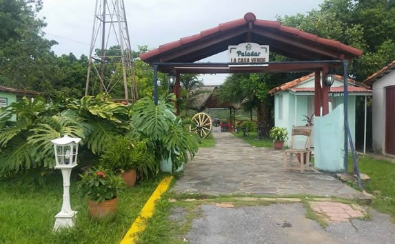 entrance with wooden sign surrounded by greenery