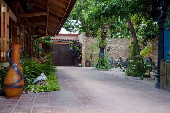 entrance with wooden gate and greenery