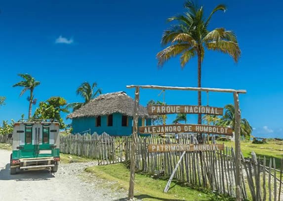 rustic sign at the entrance to the park and palms