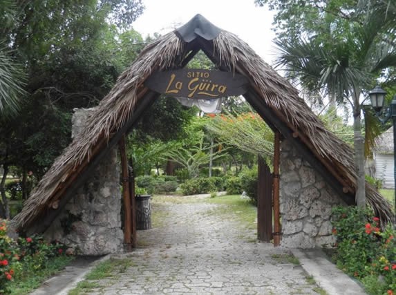 entrance with guano roof and wooden sign