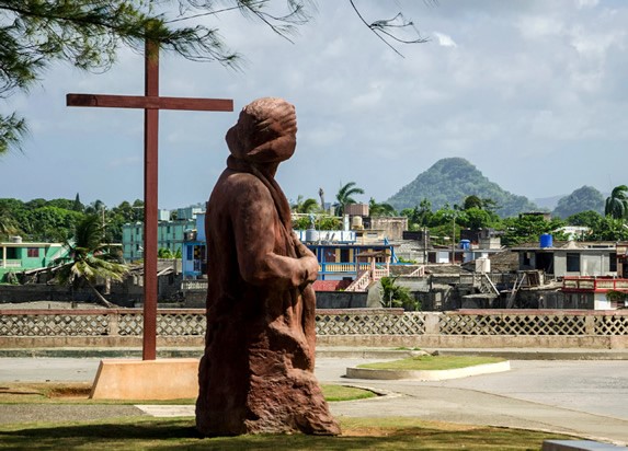 parque con estatua de peidra y cruz de madera 