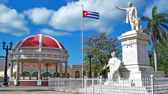 estatua de mármol y bandera cubana cercadas