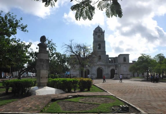 plaza con iglesia rodeada por vegetación