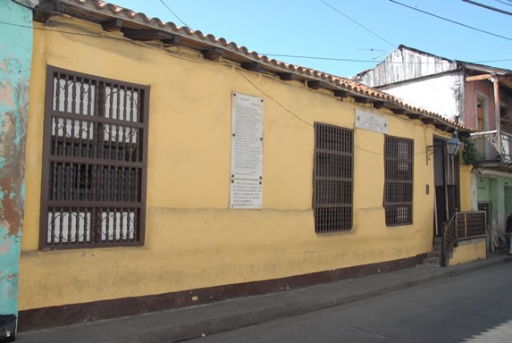 fachada amarilla con techo de tejas rojas