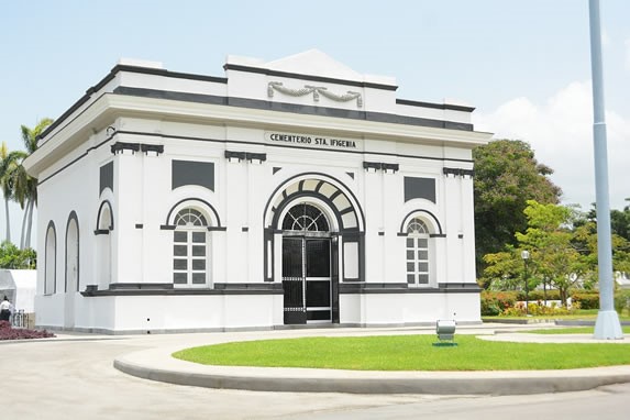 fachada colonial blanca rodeada de vegetación