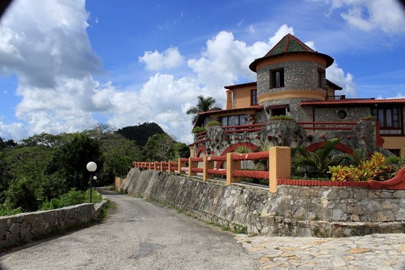 fachada de piedra del hotel rodeado de vegetación