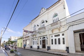 fachada colonial con balcones y cartel 