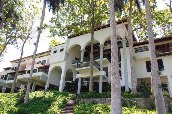 fachada del hotel rodeado de vegetación