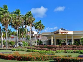 fachada del hotel rodeado de palmeras y vegetación
