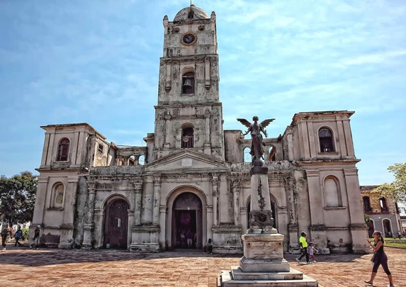 colonial church with statue under blue sky