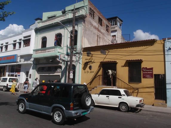 Yellow colonial facade surrounded by buildings.