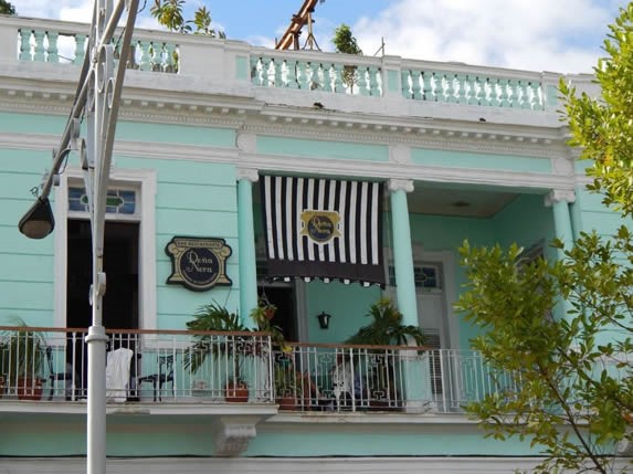 fachada colonial con balcones y letrero