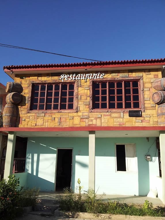 fachada de piedra del restaurante con cartel