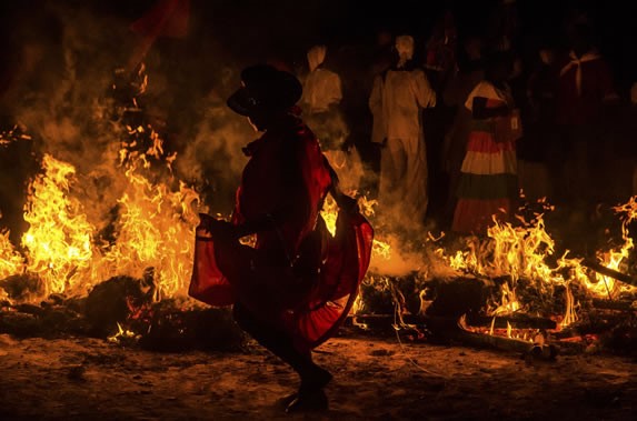 hombres bailando alrededor de fuego