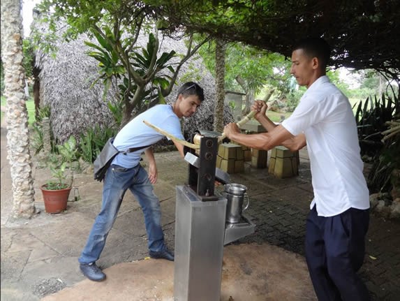 men squeezing sugarcane to obtain juice