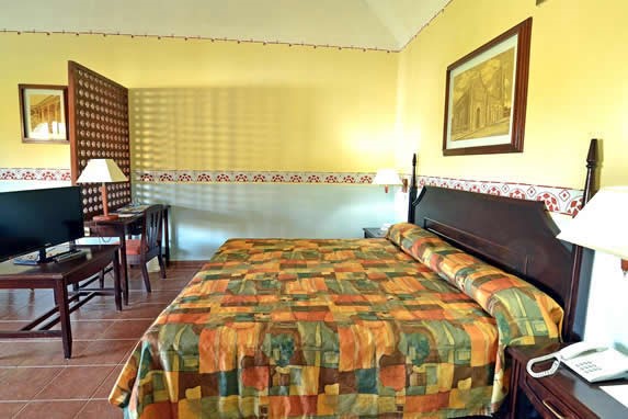 habitación de una cama con muebles de madera y TV