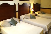 habitación de tres camas con mobiliario de madera