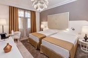 habitación de dos camas con mobiliario blanco