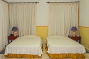 habitación de dos camas con mobiliario y cortinas